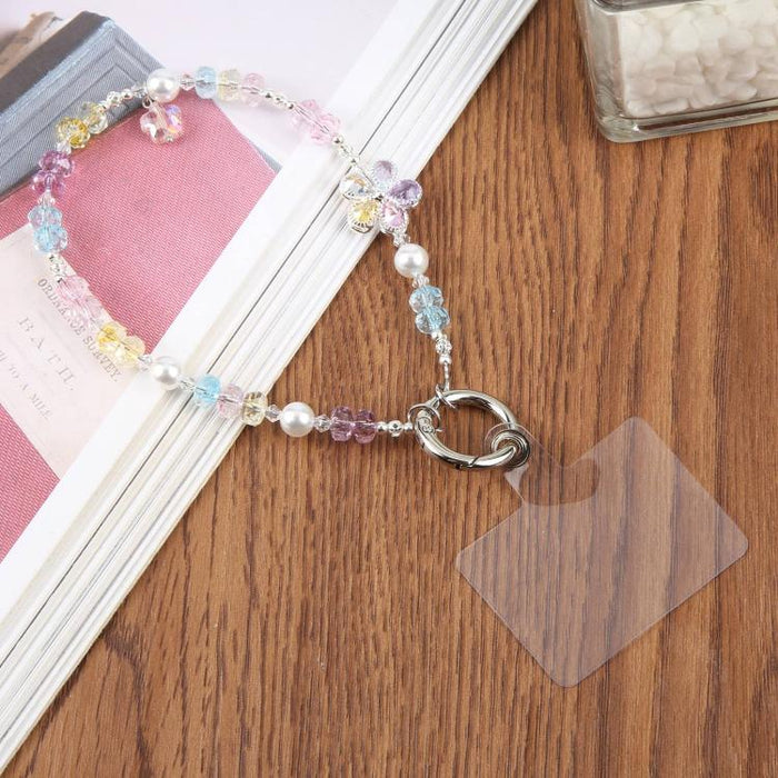 Correa de muñeca para teléfono con colgante de flores y cuentas, con almohadilla de sujeción para mujeres y niñas.