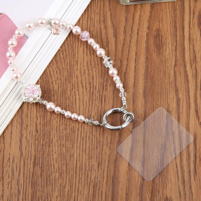 Correa de muñeca para teléfono con flor de perlas de circonita y almohadilla de sujeción para mujeres y niñas.
