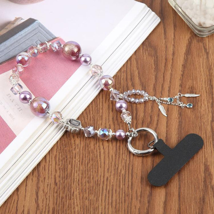 Correa de muñeca con colgante para teléfono, borla de plumas y cuentas, con almohadilla de sujeción para mujeres y niñas.