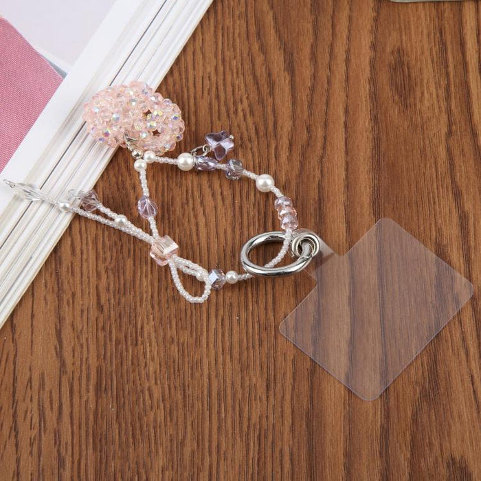 Correa de muñeca para teléfono con dije de corazón trenzado y cuentas, con almohadilla de sujeción para mujeres y niñas.