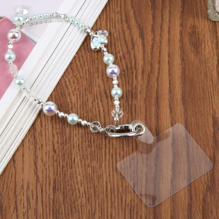 Correa para teléfono con dije de lazo de corazón de perlas