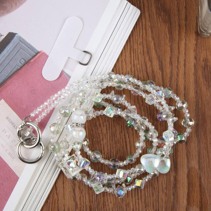 Colgante para teléfono con forma de corazón y cuentas, con cordón cruzado y almohadilla de sujeción.