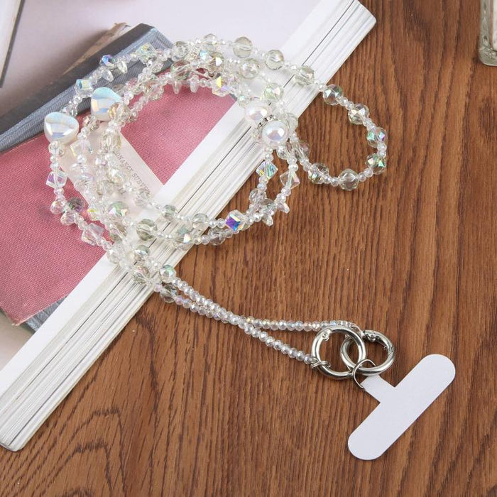 Colgante para teléfono con forma de corazón y cuentas, con cordón cruzado y almohadilla de sujeción.