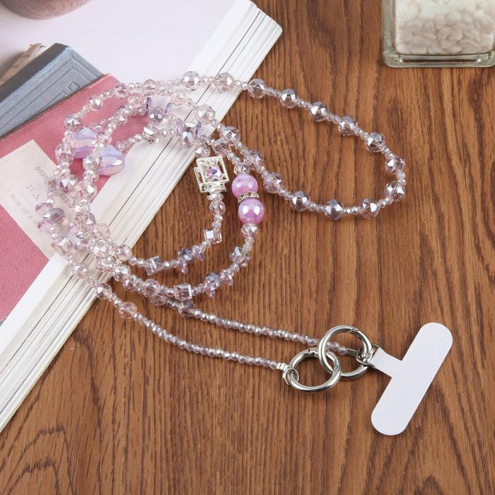 Colgante para teléfono con forma de corazón y cuentas, con cordón cruzado y almohadilla de sujeción.