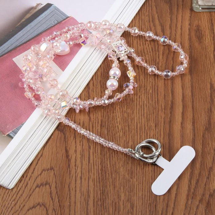 Colgante para teléfono con forma de corazón y cuentas, con cordón cruzado y almohadilla de sujeción.