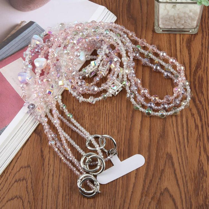 Colgante para teléfono con forma de corazón y cuentas, con cordón cruzado y almohadilla de sujeción.